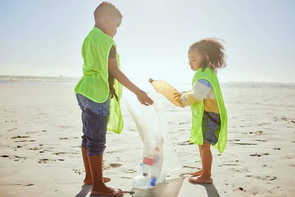 Niños implementando un estilo de vida sostenible limpiando la playa