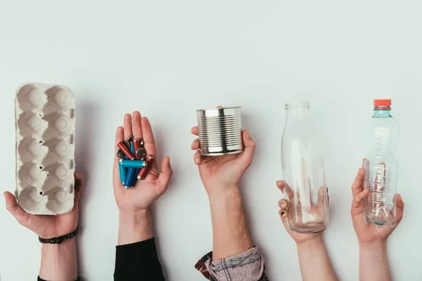 manos sosteniendo cosas reciclables aplicando la economia circular en la vida diaria
